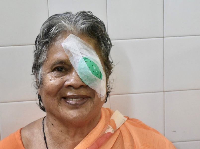 Patient smiling after successful cataract surgery with eye patch.
