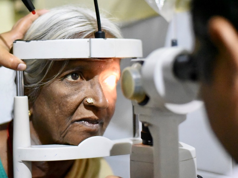 Close-up of slit lamp examination showing light focused on patient's eye.